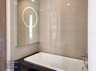 Modern bathroom with bathtub and backlit mirror