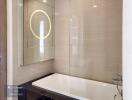 Modern bathroom with bathtub and backlit mirror