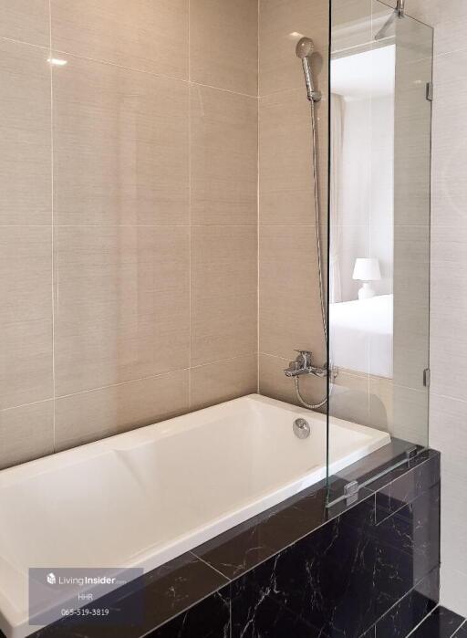 Modern bathroom with bathtub and glass shower partition