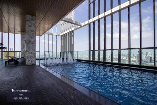 Rooftop swimming pool with lounge chairs and city view