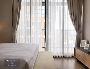 Bedroom with large windows and long curtains