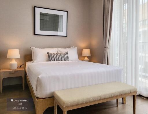 Cozy and modern bedroom with a double bed, bedside tables, lamps, and a wall art piece.