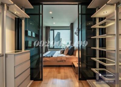 A modern bedroom with a walk-in closet and a city view