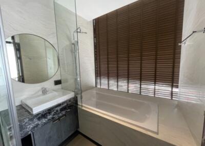 Modern bathroom with a bathtub and round mirror