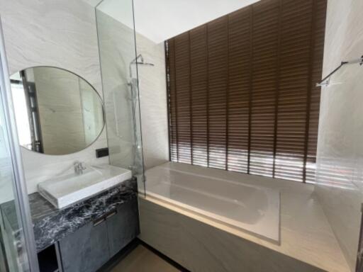 Modern bathroom with a bathtub and round mirror