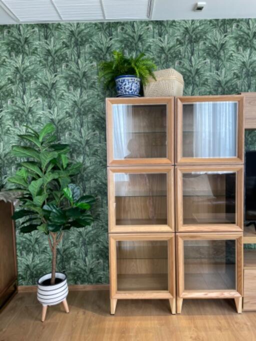 Living room with wooden storage units and green plants