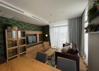 Modern living room with wooden furniture and green wall