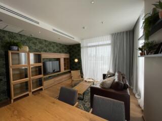 Modern living room with wooden furniture and green wall