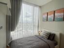 Modern bedroom with large window and gray bedding