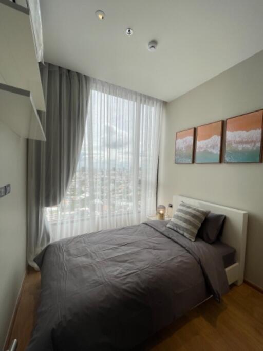 Modern bedroom with large window and gray bedding