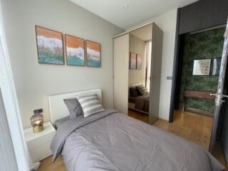 Modern bedroom with a single bed, mirrored closet, and decorative art pieces