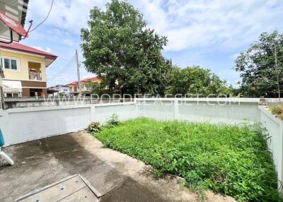 Photo of an outdoor area with a lawn and concrete pavement