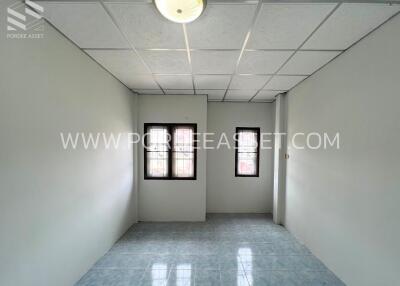 Empty bedroom with two windows and tiled floor