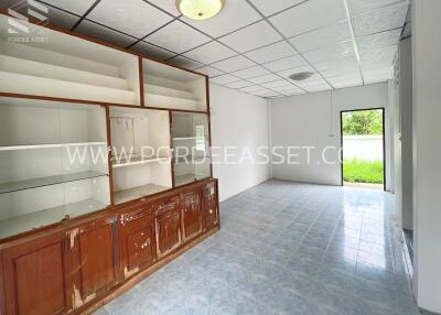 Spacious living area with tiled floor and built-in cabinets