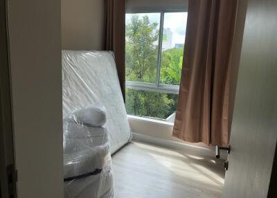 Bedroom with window view and unpacked mattress