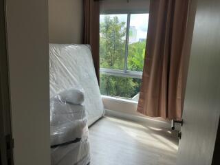 Bedroom with window view and unpacked mattress