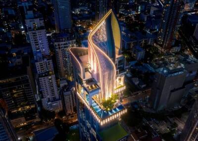 Aerial view of a modern high-rise building with unique architectural design at night