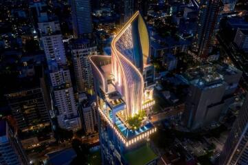 Aerial view of a modern high-rise building with unique architectural design at night