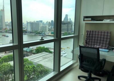 Bedroom with large window offering city and river views