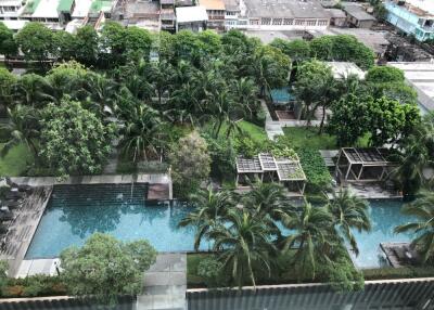 Aerial view of a luxurious outdoor area with multiple swimming pools and abundant greenery.