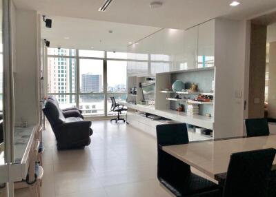 Modern living and dining area with large windows and built-in shelving