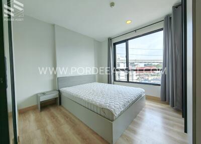 Modern bedroom with large window, wooden flooring, and minimalistic decor