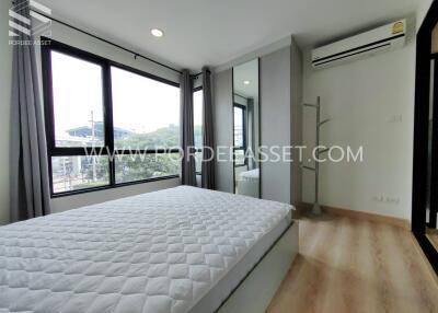 Modern bedroom with large windows, built-in wardrobe, and air conditioning