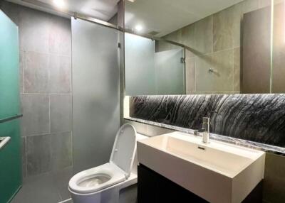 Modern bathroom with glass shower and backlit mirror