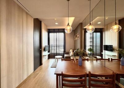 Modern living room with large windows, wooden walls, dining table with chairs, and pendant lighting