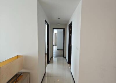 Bright hallway with white tiles leading to multiple rooms