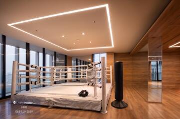 Modern fitness room with boxing ring and punching bag