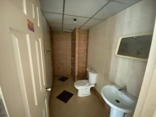 View of a bathroom with a toilet, sink, and shower area