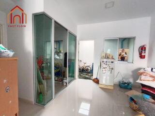 Room with sliding glass doors, fridge, and storage