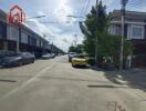 Photo of the residential street featuring multiple modern townhouses and parked cars.