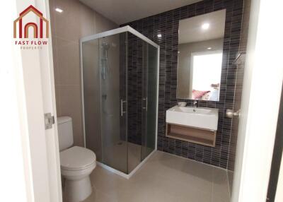 Modern bathroom with a shower enclosure, toilet, and a sink with a mirror