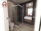 Modern bathroom with a shower enclosure, toilet, and a sink with a mirror