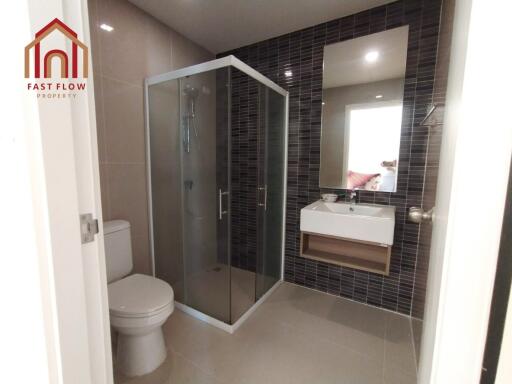 Modern bathroom with a shower enclosure, toilet, and a sink with a mirror