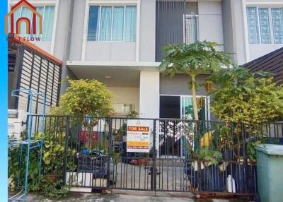 Exterior view of a modern townhouse with a for sale sign