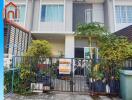 Exterior view of a modern townhouse with a for sale sign