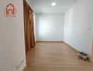 Empty bedroom with curtains and wooden floor