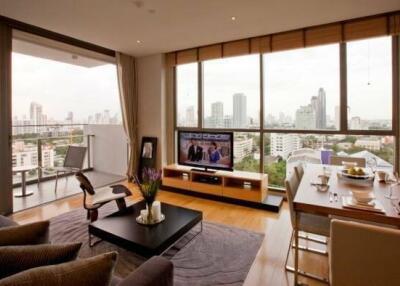 Modern living room with city view, balcony, and dining table