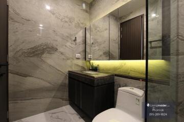 Modern bathroom with marble walls and large mirror