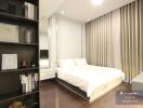 Modern and spacious bedroom with a large bed, floor-to-ceiling curtains, and stylish bookshelf