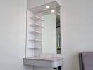 Modern vanity area with shelves and mirror in a bedroom