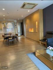 Modern living and dining area with wooden flooring and built-in cabinetry