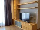 Modern living room with wooden TV stand and shelving