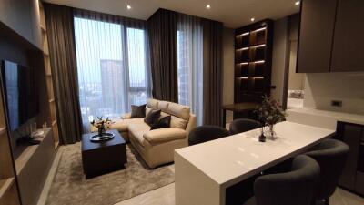 Modern living room with a beige sofa, dining table, and large windows