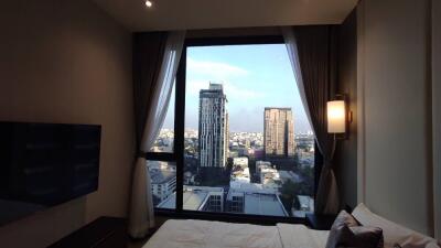 Bedroom with a city view from a large window