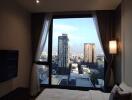 Bedroom with a city view from a large window