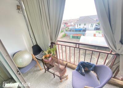 Covered balcony with seating and view of neighboring houses